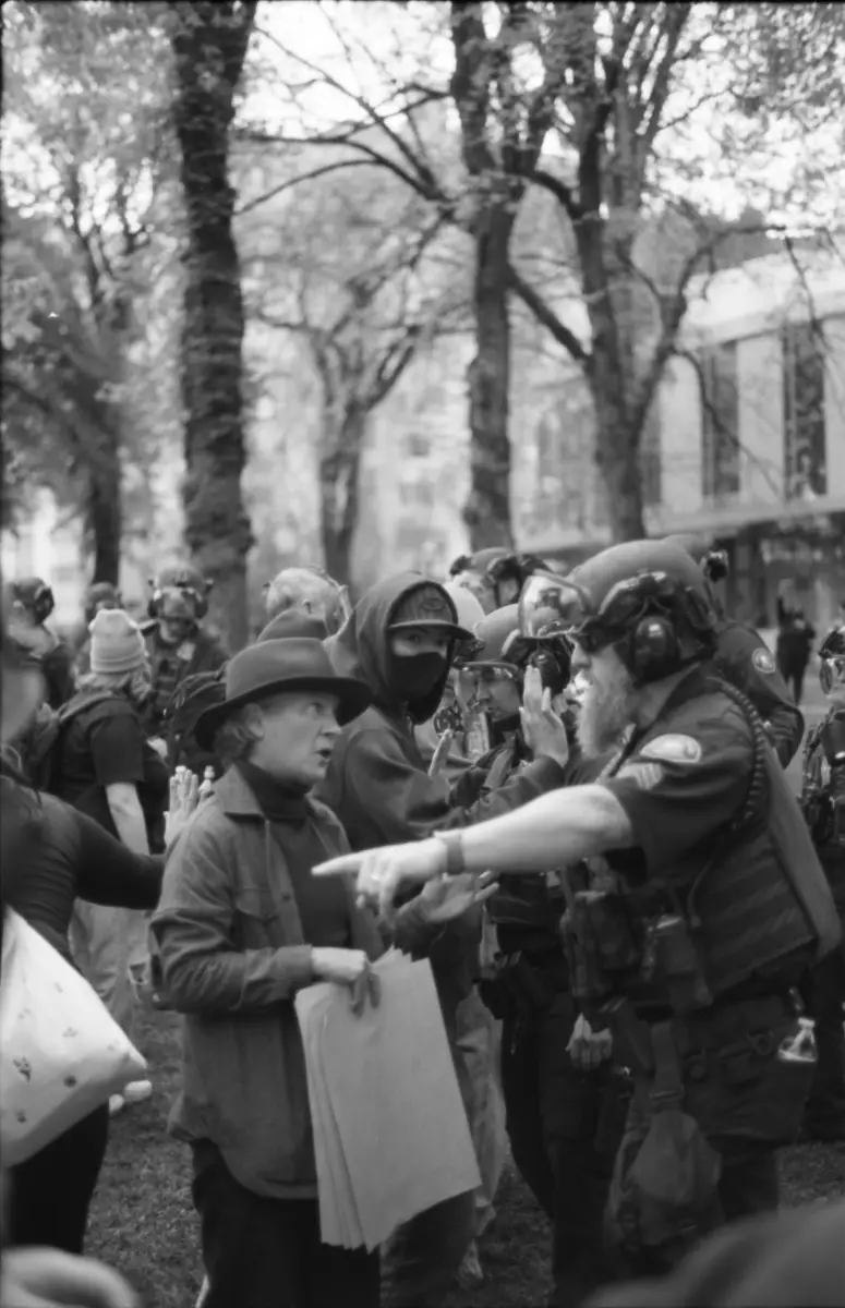 A photo of a police oficer arguing with a teacher at a protest