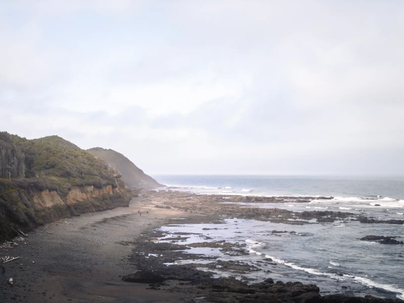 Photo of a coastline as people walk on the beach