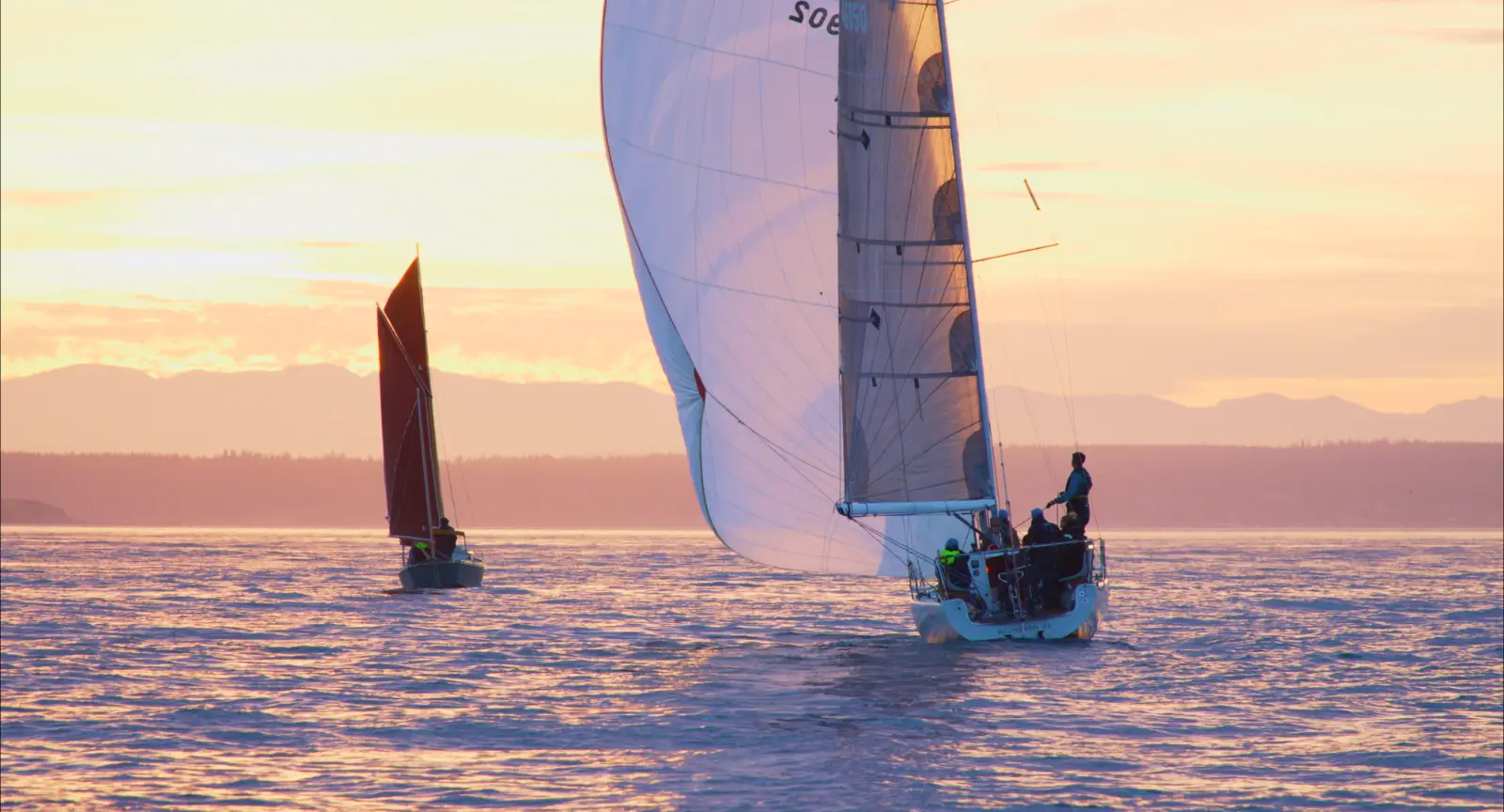 Photo of two boats sailing into a golden sunset